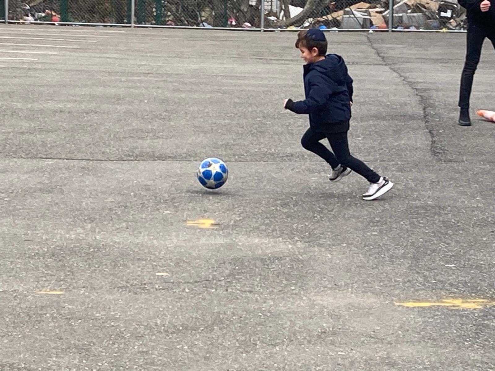 A boy chasing down a soccer ball
