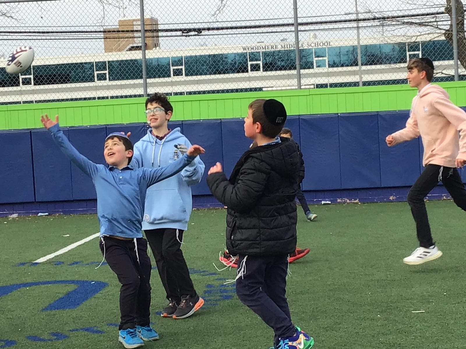 Boys reaching for a football on the field